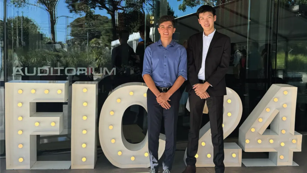 Two boys standing next to each other who have achieved first in course